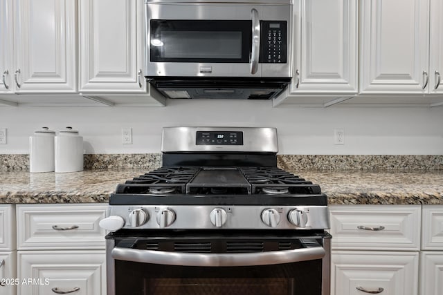 kitchen featuring white cabinetry, dark stone counters, and appliances with stainless steel finishes