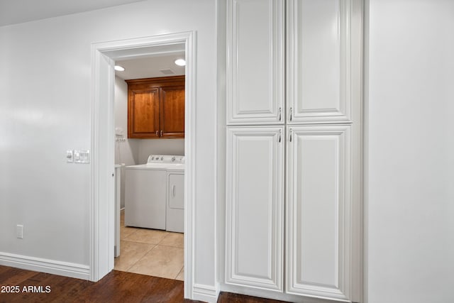 laundry room featuring light hardwood / wood-style flooring, cabinets, and independent washer and dryer