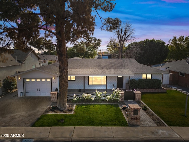 view of front of house with a garage and a lawn