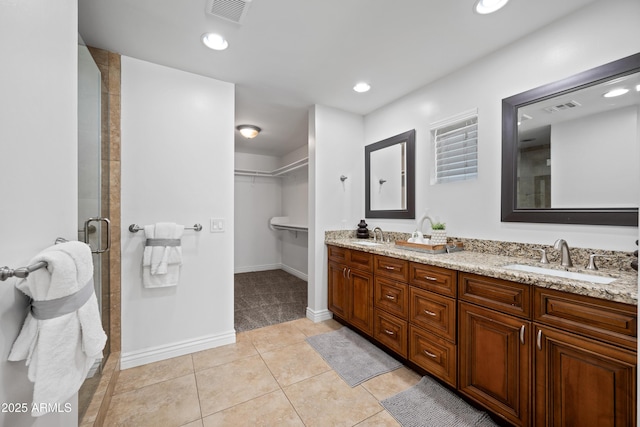 bathroom with tile patterned floors, vanity, and walk in shower