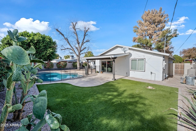 back of house featuring a yard, a fenced in pool, and a patio