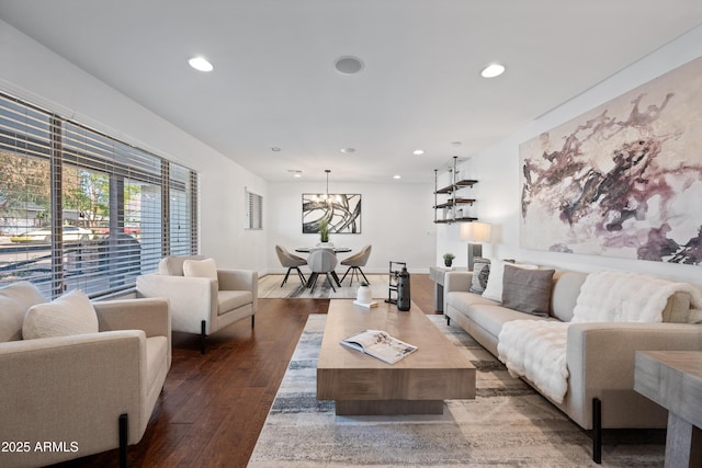 living room featuring dark hardwood / wood-style floors and an inviting chandelier