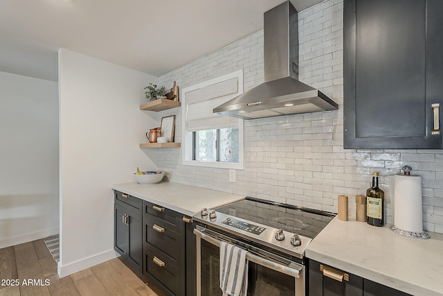 8320 E Monte Vista Rd, Scottsdale, AZ 85257 - kitchen featuring stainless steel electric stove, wall chimney exhaust hood, tasteful backsplash, light wood-style flooring, and open shelves