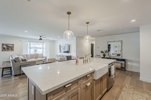 8320 E Monte Vista Rd, Scottsdale, AZ 85257 - kitchen with a sink, light wood-type flooring, a center island with sink, pendant lighting, and ceiling fan