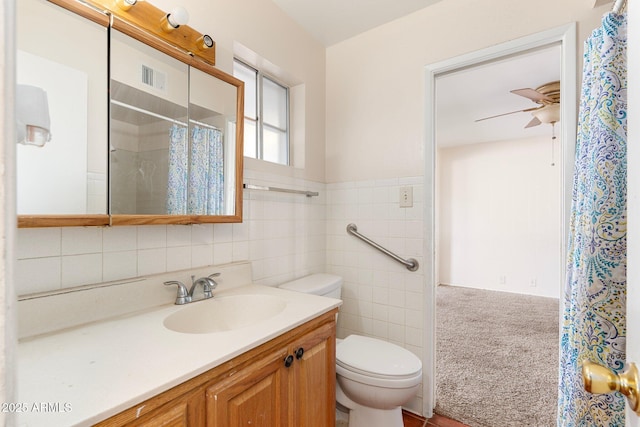 bathroom with tile walls, vanity, ceiling fan, toilet, and a shower with shower curtain