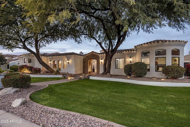 mediterranean / spanish-style house featuring a lawn