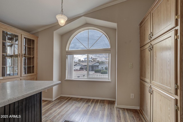 unfurnished dining area with light wood-type flooring and crown molding