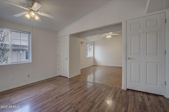 empty room with ceiling fan, dark hardwood / wood-style floors, ornamental molding, and lofted ceiling