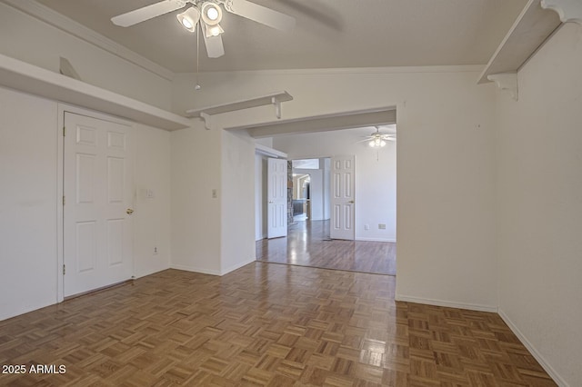 spare room featuring ceiling fan, crown molding, dark parquet floors, and vaulted ceiling