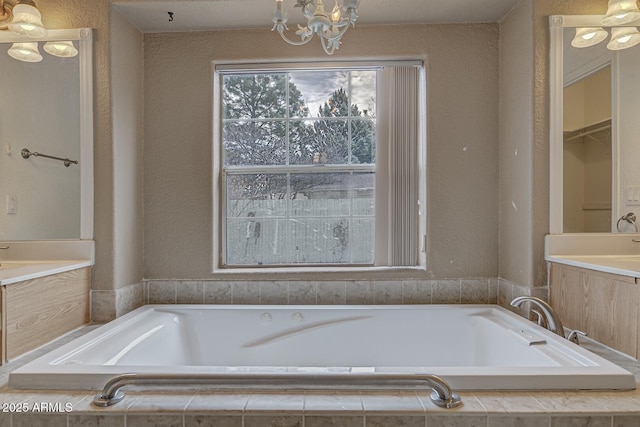 bathroom with a relaxing tiled tub and a chandelier