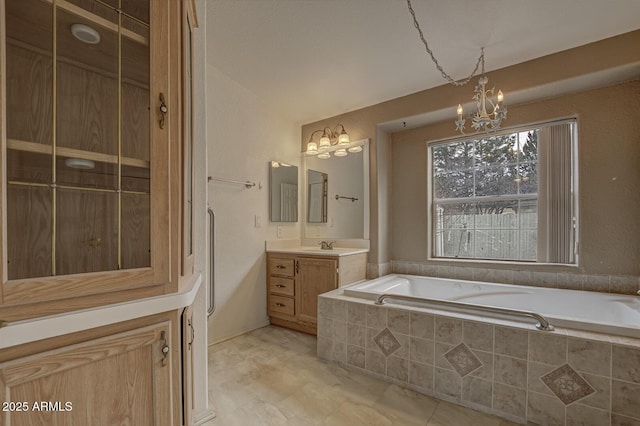 bathroom with tiled bath, vanity, vaulted ceiling, and a notable chandelier