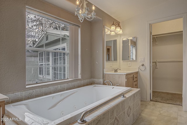 bathroom with an inviting chandelier, a relaxing tiled tub, lofted ceiling, tile patterned floors, and vanity