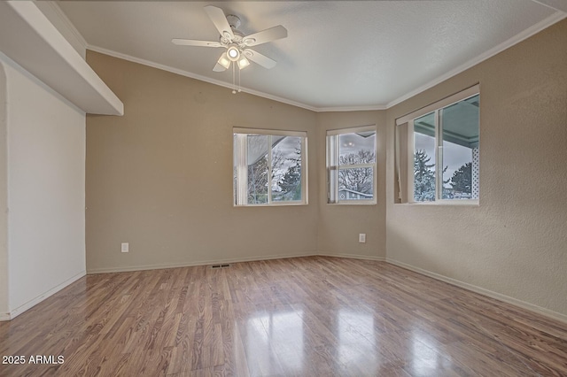 spare room with hardwood / wood-style flooring, plenty of natural light, ornamental molding, and ceiling fan