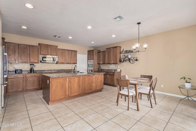 3964 E Hummingbird Ln, Phoenix, AZ 85050 - kitchen featuring appliances with stainless steel finishes, a sink, stone counters, an island with sink, and light tile patterned floors