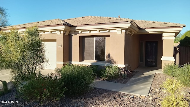 41318 N Belfair Way, Anthem, AZ 85086 - view of exterior entry with stucco siding, an attached garage, and a tile roof
