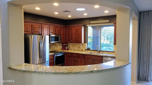 41318 N Belfair Way, Anthem, AZ 85086 - kitchen featuring appliances with stainless steel finishes, a sink, light stone counters, decorative backsplash, and recessed lighting