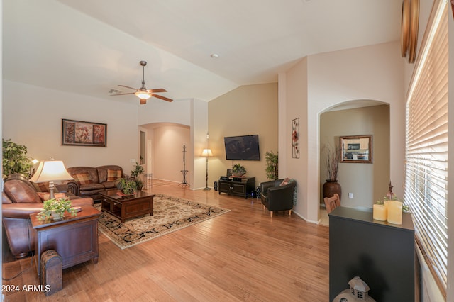 living room with light hardwood / wood-style flooring, vaulted ceiling, and ceiling fan