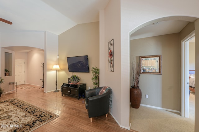 living room featuring hardwood / wood-style floors, vaulted ceiling, and ceiling fan