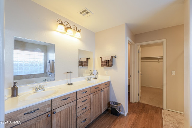 bathroom with vanity, hardwood / wood-style floors, and a bathtub