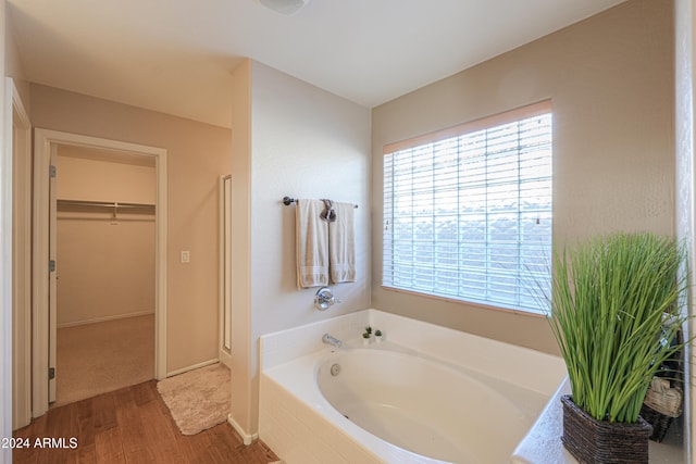 bathroom featuring hardwood / wood-style flooring and tiled tub