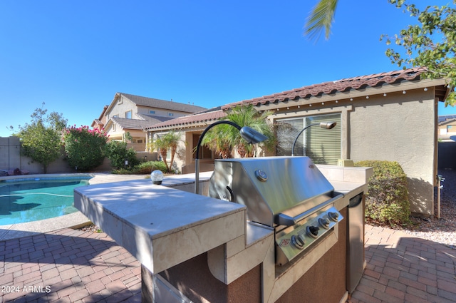 view of patio / terrace with a fenced in pool and a grill