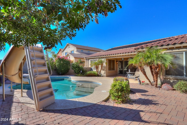 view of pool featuring a patio area and a water slide