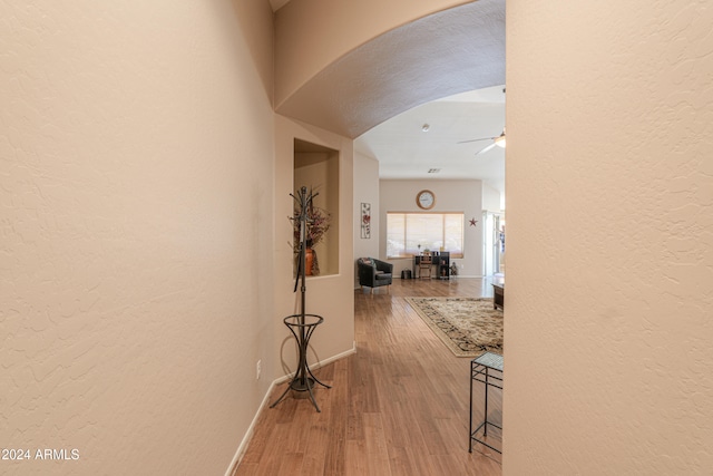 corridor with hardwood / wood-style floors and a textured ceiling