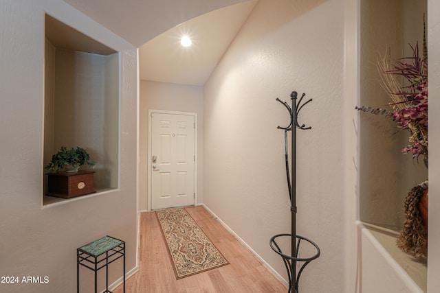 hallway featuring vaulted ceiling and hardwood / wood-style flooring