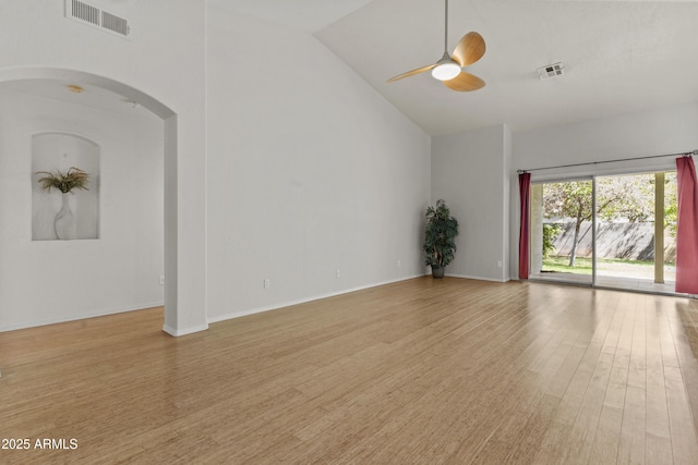 1135 W Sea Fog Dr, Gilbert, AZ 85233 - unfurnished living room with light wood-style floors, arched walkways, a ceiling fan, and vaulted ceiling