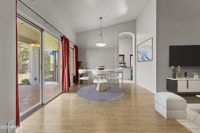 1135 W Sea Fog Dr, Gilbert, AZ 85233 - dining space featuring arched walkways, wood finished floors, and high vaulted ceiling