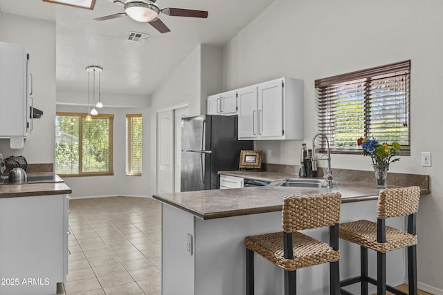 1135 W Sea Fog Dr, Gilbert, AZ 85233 - kitchen featuring freestanding refrigerator, ceiling fan, a peninsula, white cabinets, and light tile patterned floors