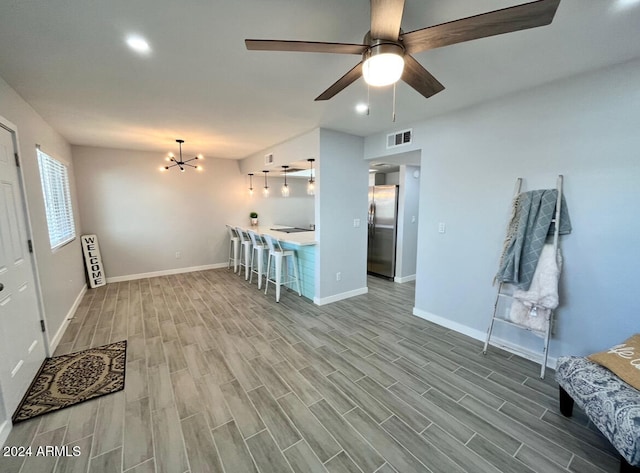 interior space featuring hardwood / wood-style floors and ceiling fan with notable chandelier