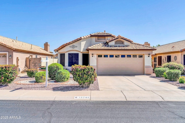 10745 W Beaubien Dr, Sun City, AZ 85373 - mediterranean / spanish home featuring fence, a tiled roof, stucco siding, an attached garage, and driveway