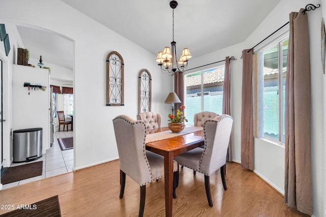 10745 W Beaubien Dr, Sun City, AZ 85373 - dining space featuring arched walkways, a healthy amount of sunlight, light wood finished floors, and a notable chandelier
