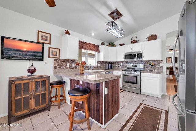 10745 W Beaubien Dr, Sun City, AZ 85373 - kitchen featuring lofted ceiling, stainless steel appliances, a peninsula, and backsplash