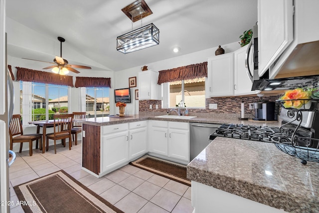 10745 W Beaubien Dr, Sun City, AZ 85373 - kitchen with stainless steel dishwasher, decorative backsplash, ceiling fan, a peninsula, and lofted ceiling