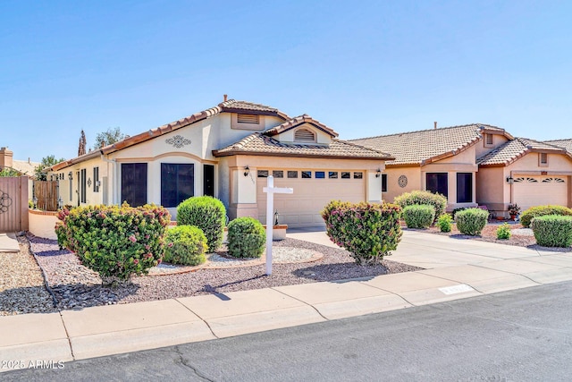 10745 W Beaubien Dr, Sun City, AZ 85373 - mediterranean / spanish house featuring a tile roof, concrete driveway, fence, a garage, and stucco siding