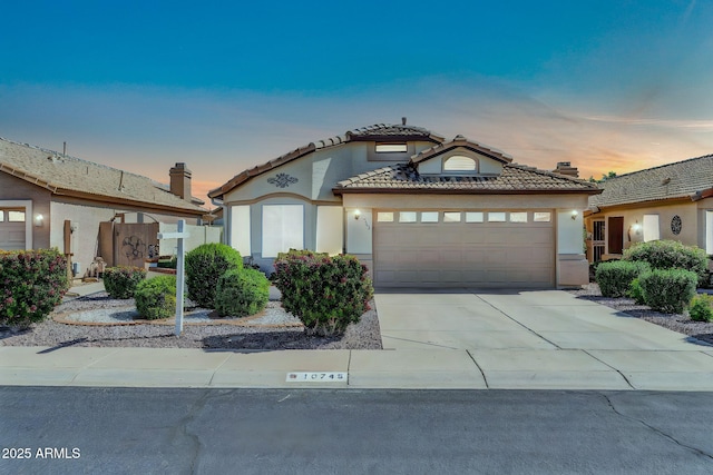 10745 W Beaubien Dr, Sun City, AZ 85373 - mediterranean / spanish home with an attached garage, a tiled roof, stucco siding, and driveway
