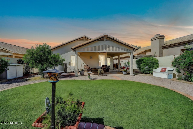 10745 W Beaubien Dr, Sun City, AZ 85373 - back of house with a ceiling fan, a fenced backyard, a yard, stucco siding, and a patio