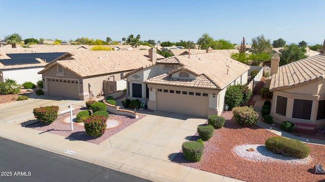 10745 W Beaubien Dr, Sun City, AZ 85373 - view of front of house featuring a tiled roof, driveway, a chimney, an attached garage, and stucco siding