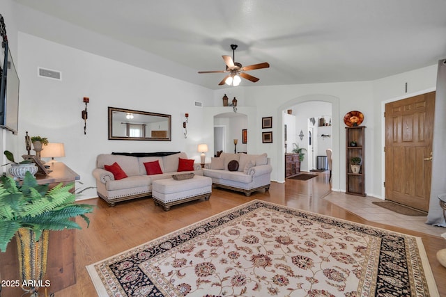 10745 W Beaubien Dr, Sun City, AZ 85373 - living room featuring ceiling fan, arched walkways, wood finished floors, and visible vents