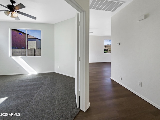 empty room featuring a healthy amount of sunlight, ceiling fan, visible vents, and baseboards