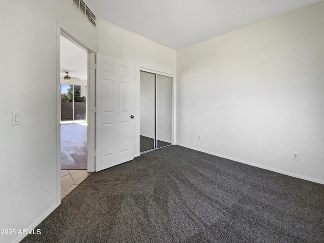 unfurnished bedroom with carpet floors, a closet, visible vents, and baseboards