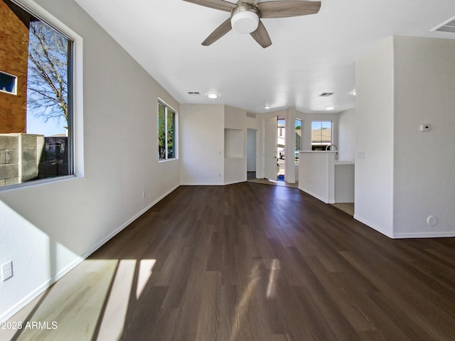 unfurnished living room featuring visible vents, ceiling fan, baseboards, and wood finished floors