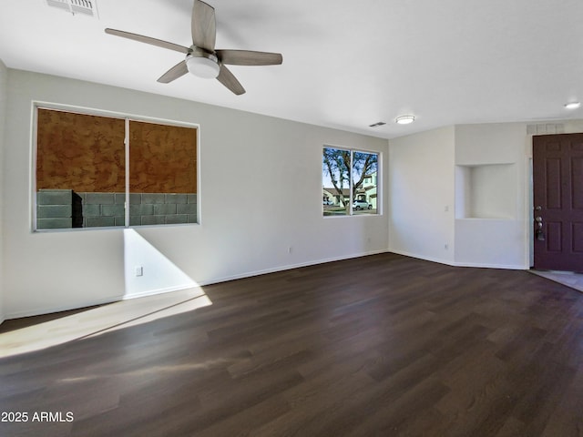 empty room with visible vents, ceiling fan, baseboards, and wood finished floors