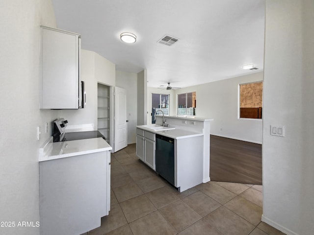 kitchen with visible vents, stove, a sink, tile patterned flooring, and dishwashing machine