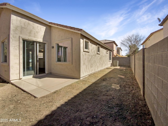 rear view of property featuring a patio area, a fenced backyard, and stucco siding