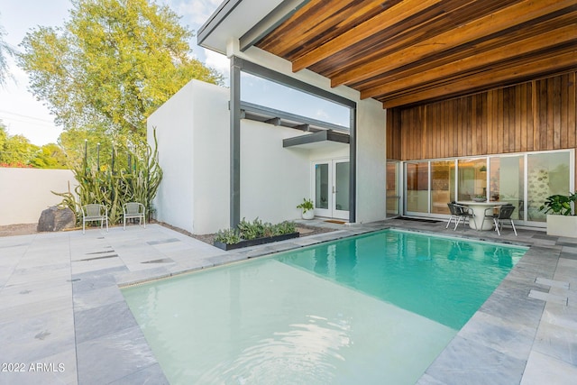 view of pool with french doors and a patio