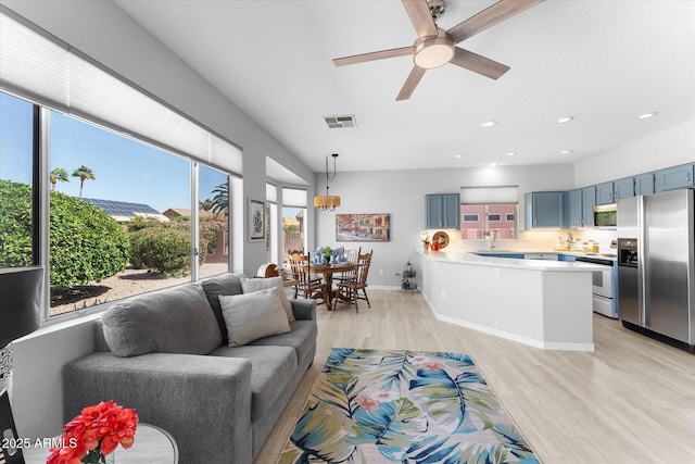 living area featuring recessed lighting, visible vents, light wood-style flooring, and a ceiling fan