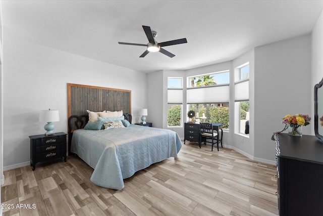 bedroom featuring baseboards, light wood-type flooring, and ceiling fan